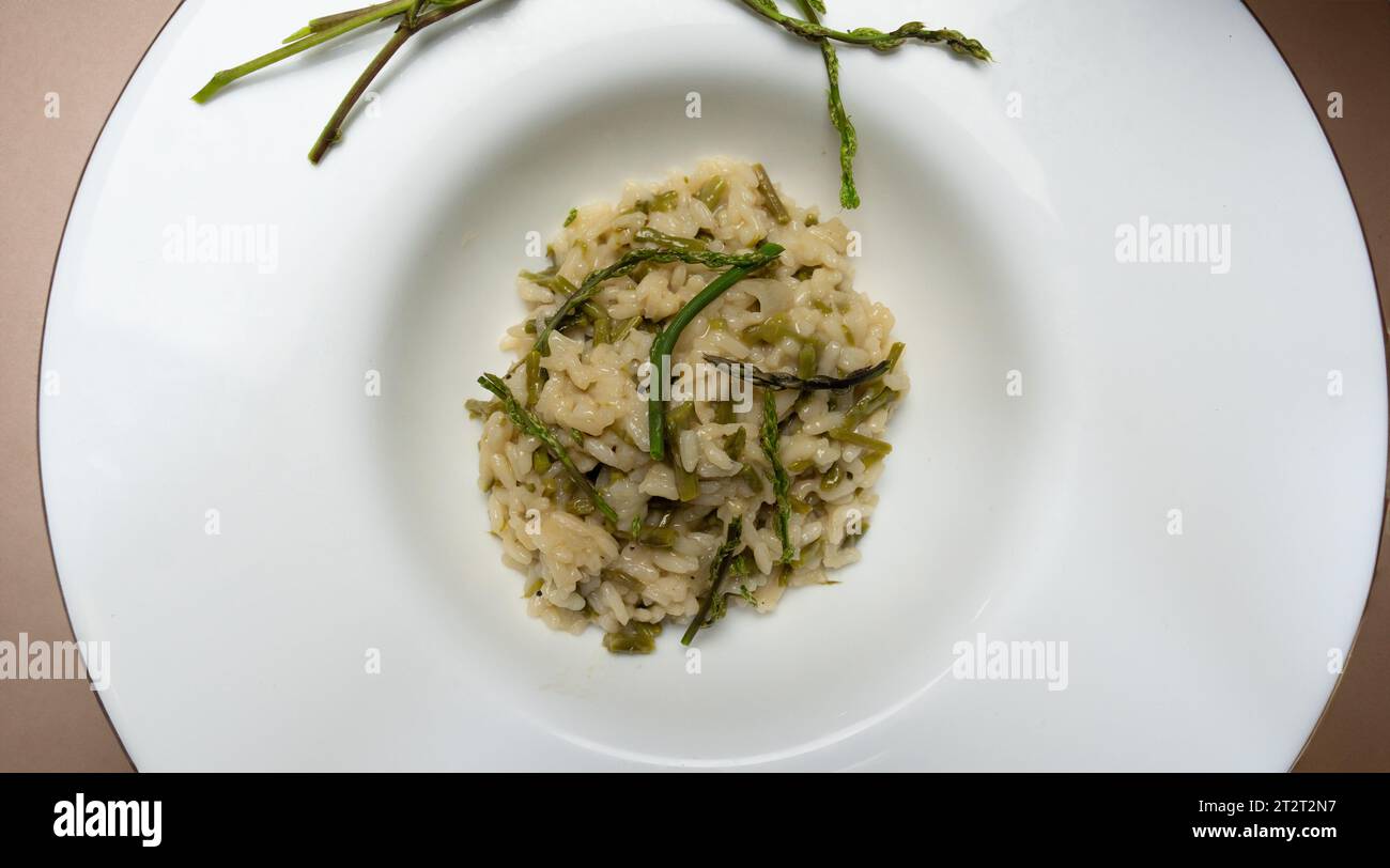risotto with wild asparagus ,asparagus acutifolius, on white plate Stock Photo