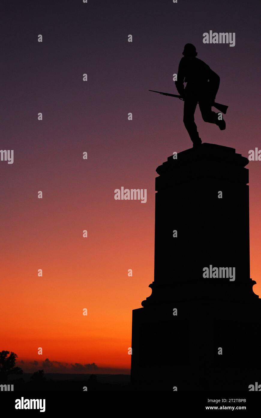 A memorial to the First Minnesota Volunteer Infantry depicts a charging soldier with a bayonete and silhouetted against a dusk sky at Gettysburg Stock Photo