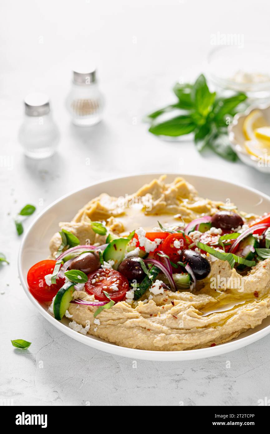 Greek style vegan mediterranean hummus with fresh vegetables, olives, olive oil and feta cheese Stock Photo