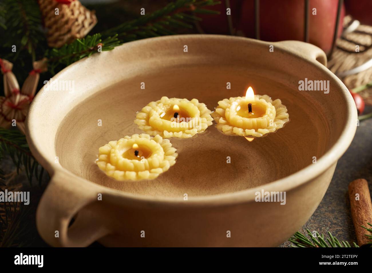 Candles made from bees wax floating in a bowl of water at Christmas