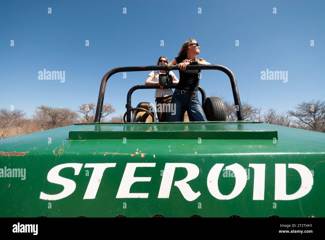 Two sisters look for game from the back of a farm 4x4 vehicle in Thabazimbi in South Africa Stock Photo