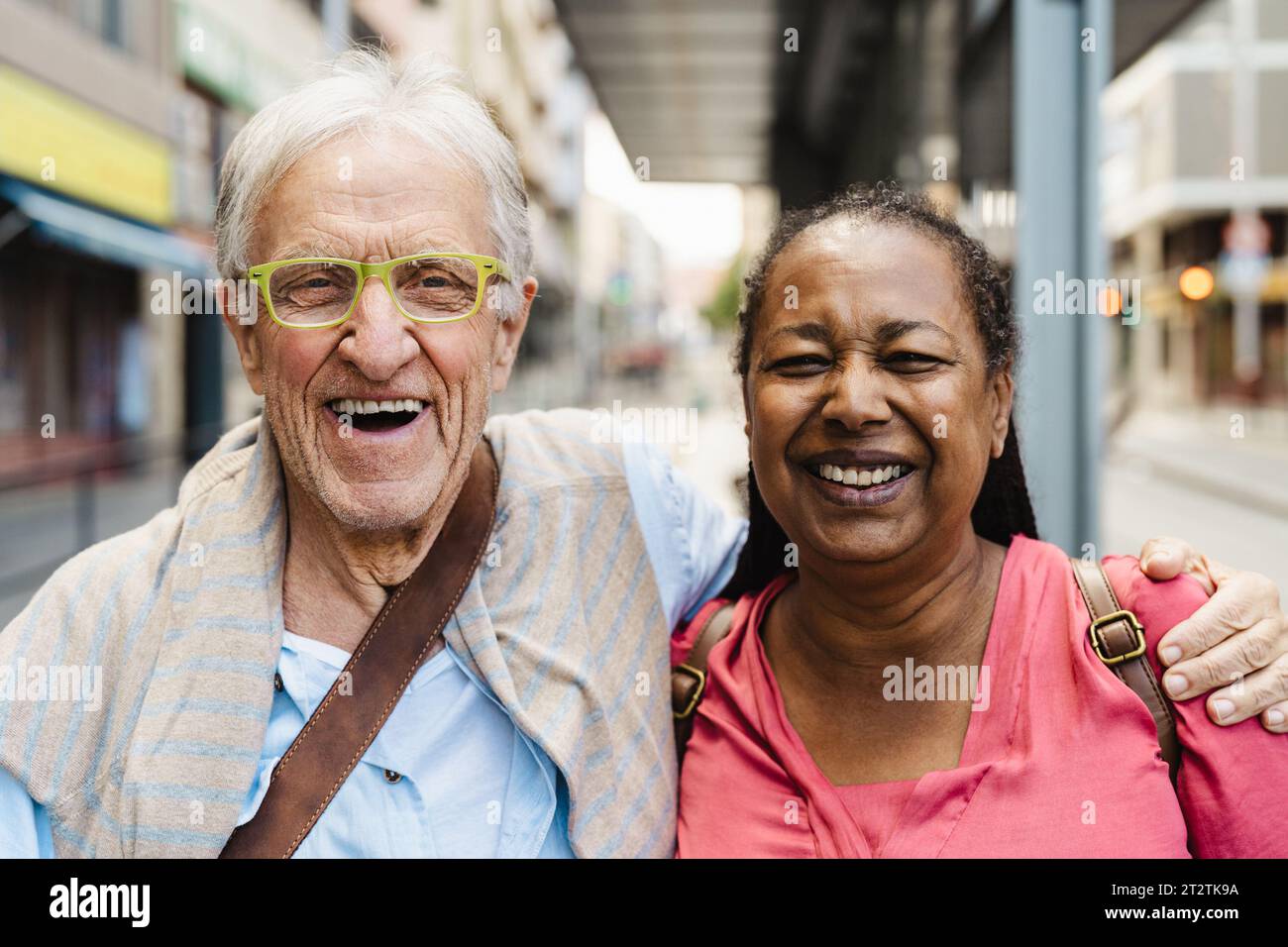 Happy multiracial senior friends having fun while waiting at the bus station Stock Photo