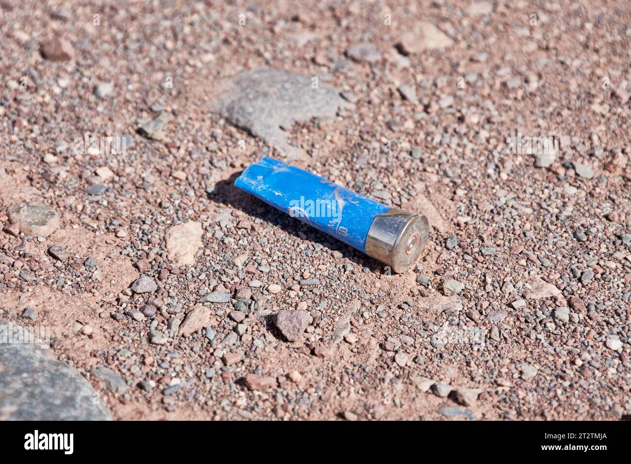 Empty blue gun casing on a dirt road out hunting grounds. Plastic