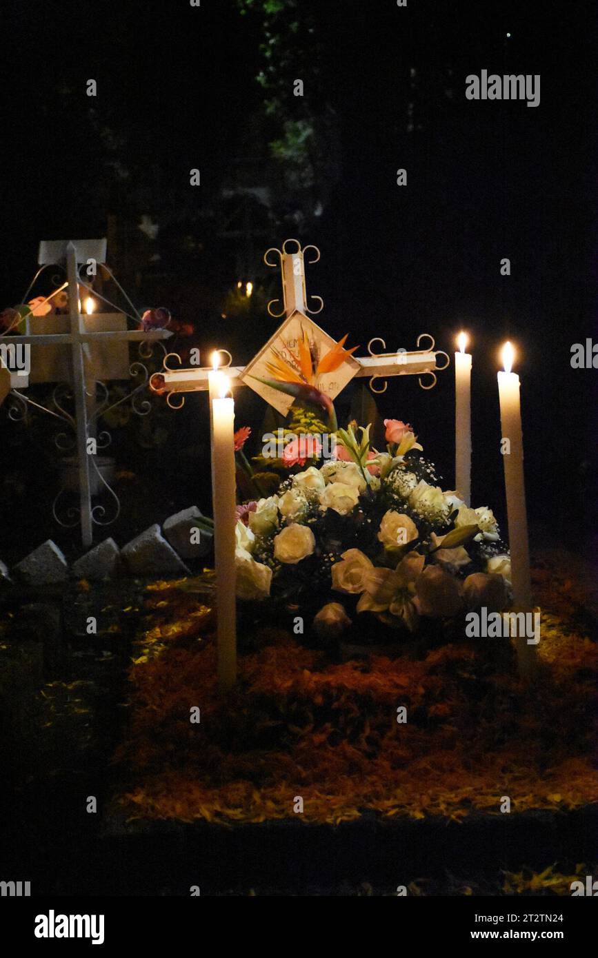 Decorated graves at night during Day of the Dead in San Gregorio