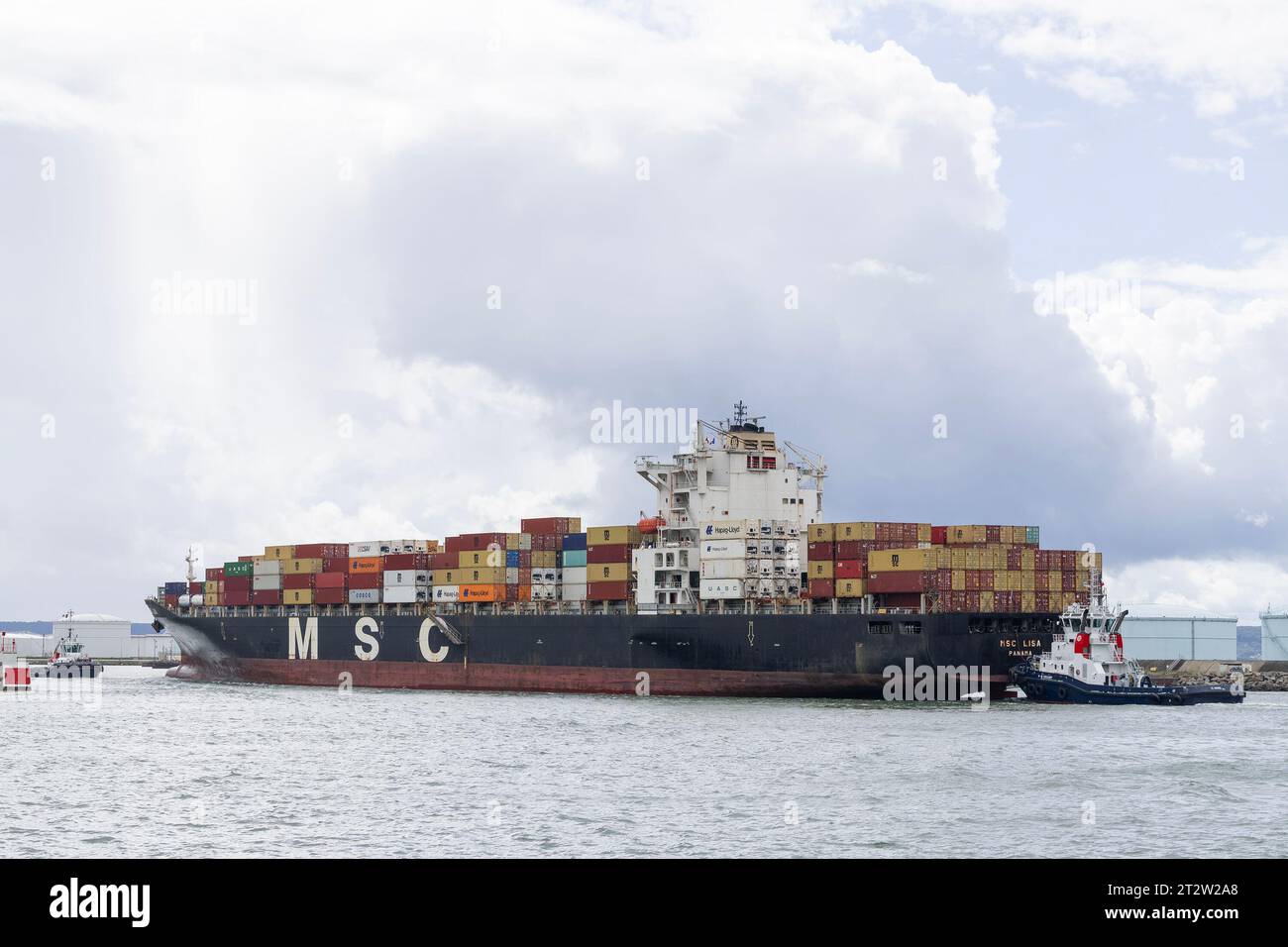 Le Havre, France - Container Ship MSC LISA arriving port of Le Havre with tugboats. Stock Photo