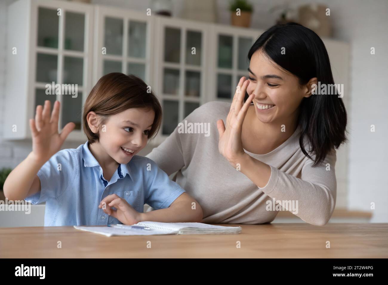 Happy Asian mother and son student giving high five Stock Photo