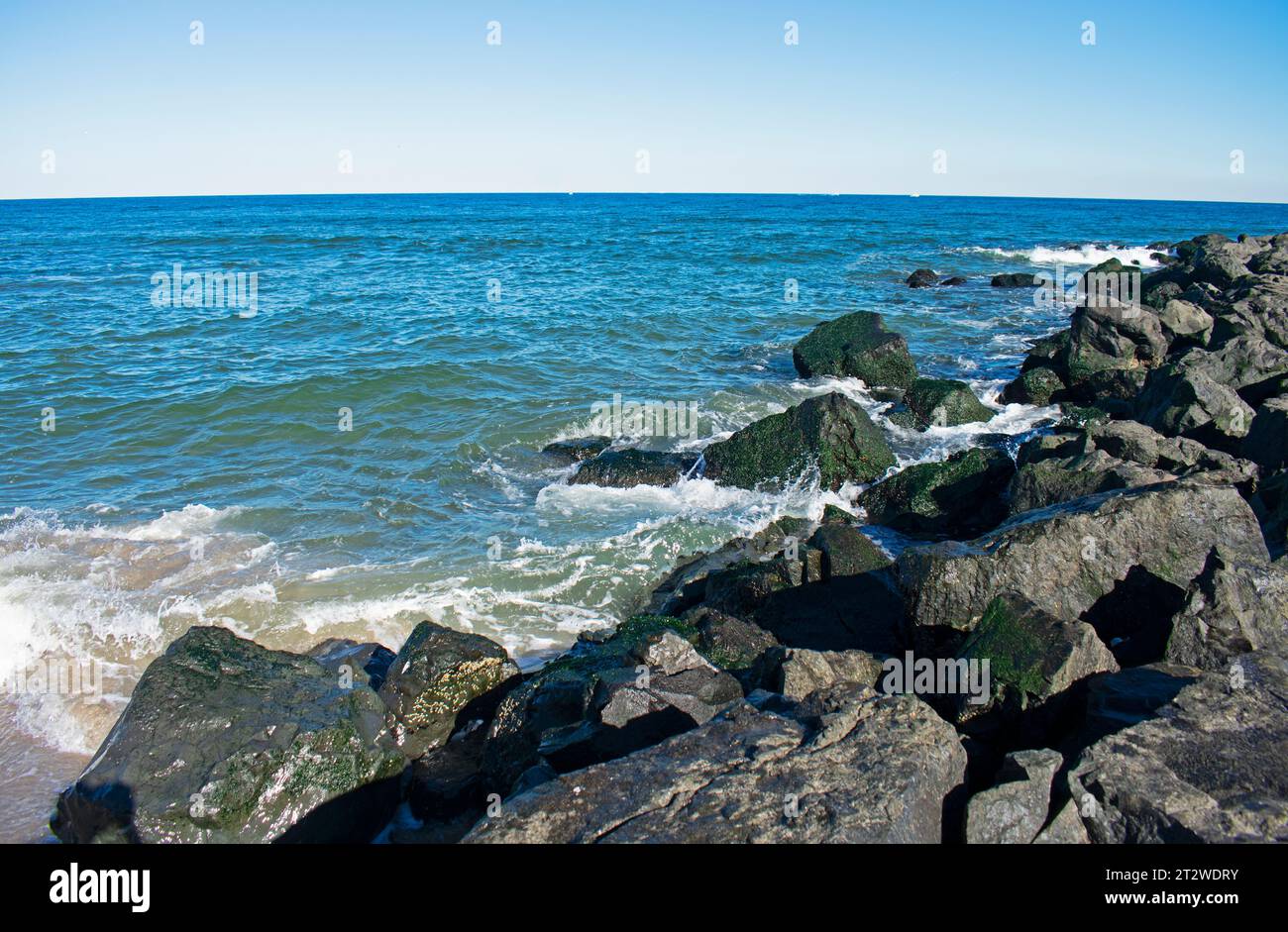 Surf crashes into shore and rock jetty on a sunny autumn day in Asbury Park, New Jersey -04 Stock Photo