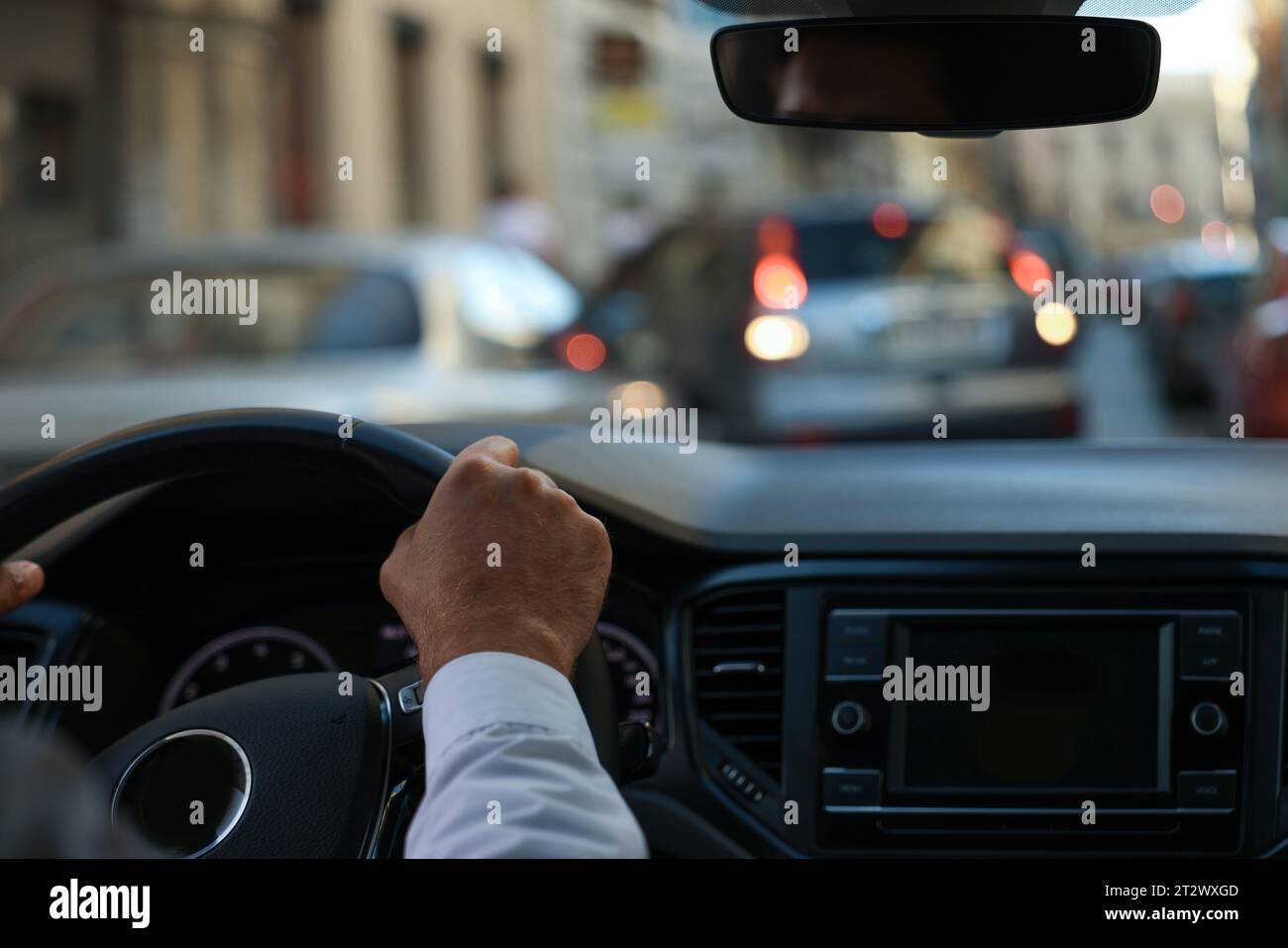 Stuck in traffic jam. Driver holding hands on steering wheel in car