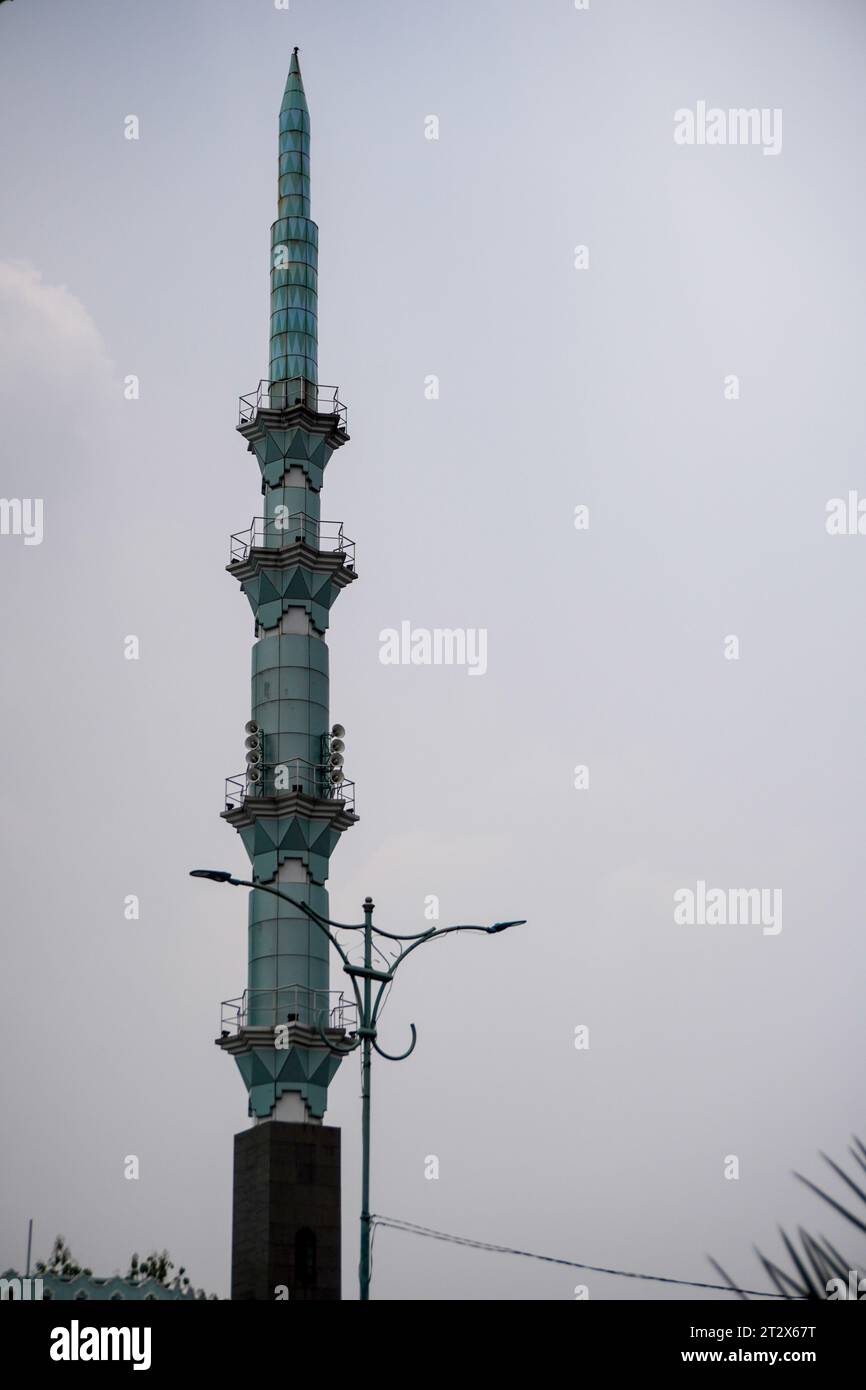 The beautiful mosque tower is green, with garden lights. sky background in the afternoon. Stock Photo