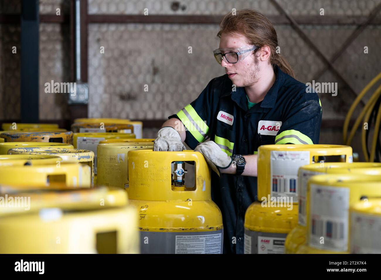An operator prepares used cylinders to be drained of remaining ...