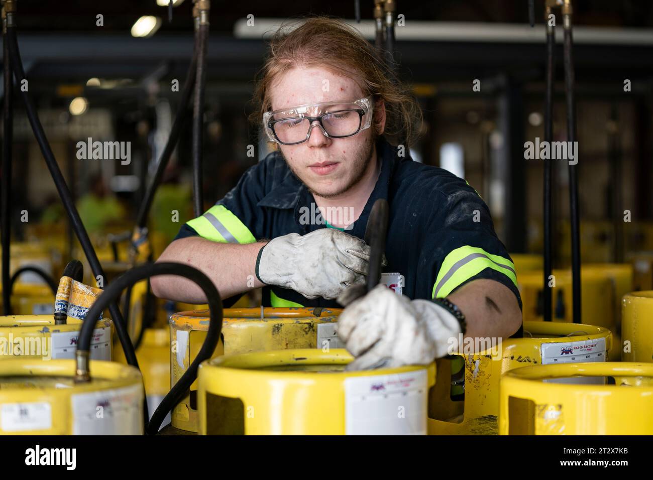 An operator prepares used cylinders to be drained of remaining ...