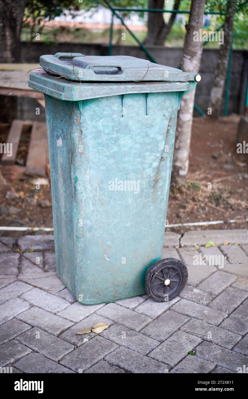 https://c8.alamy.com/comp/2T2X811/green-trash-cans-are-on-the-side-of-the-road-it-looks-worn-out-with-the-color-starting-to-fade-2T2X811.jpg