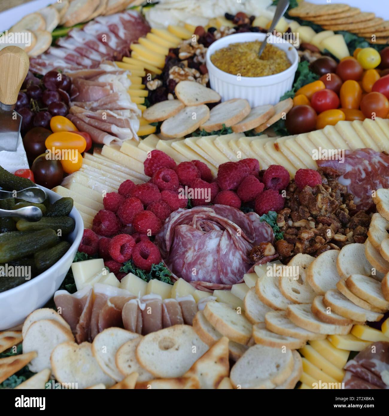 A festive platter with a variety of cured meats, artisanal cheeses, and crackers Stock Photo