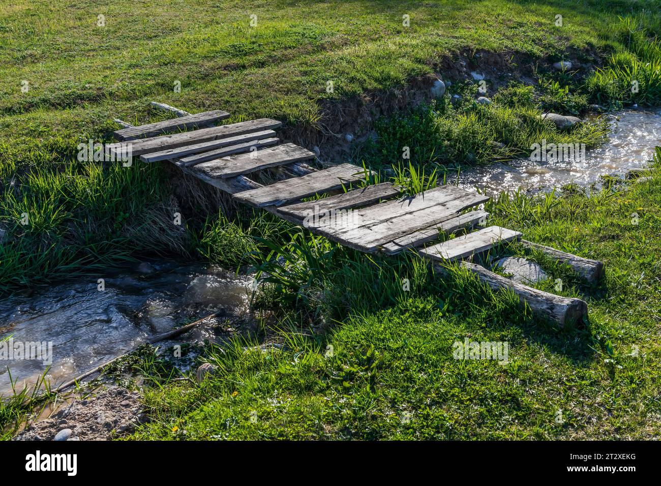 Wooden bridge over a village river Stock Photo - Alamy