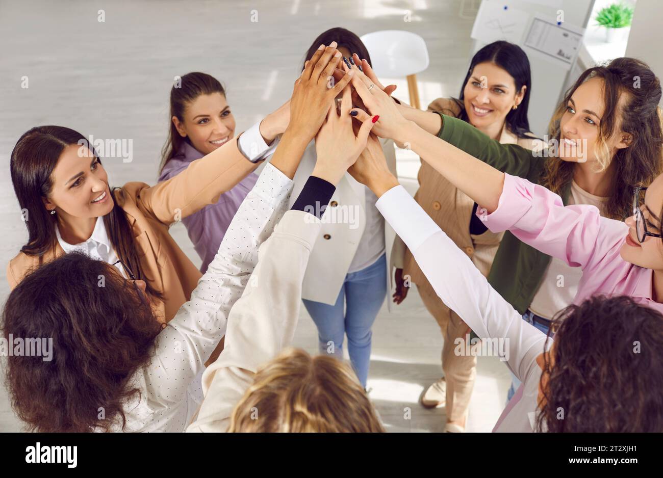 Group of smiling young women doing high five gesture Stock Photo