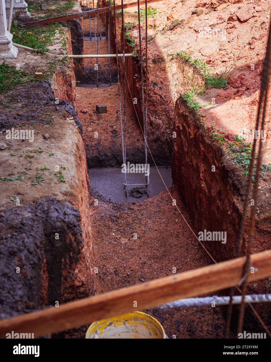 Wet Concrete inside a ground hole. Making a foundation with steel rebar. Stock Photo