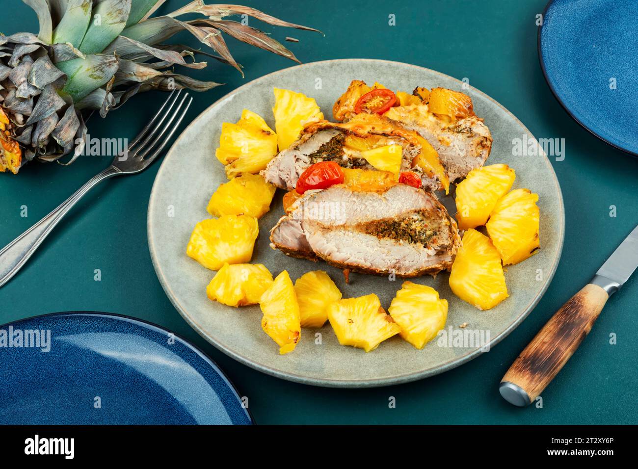 Appetizing meat roasted with fresh pineapple, colorful food. Stock Photo