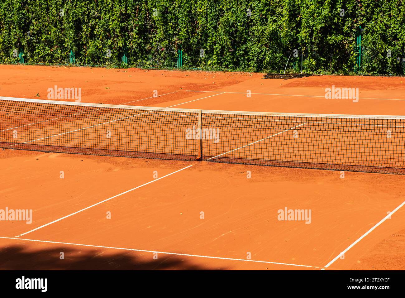 Tennis court with a sand surface and a stretched net for playing a