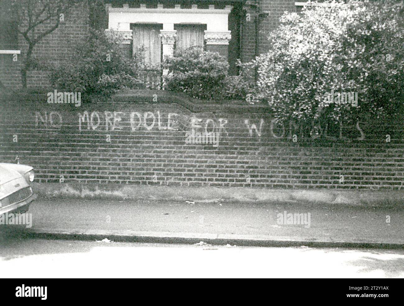 1970s black & white archive photograph of humourous graffiti in Clapham, South London, reads No More Dole for Wombles. Stock Photo
