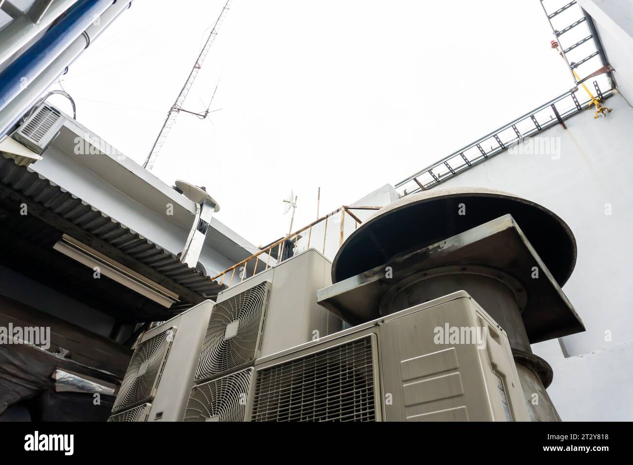 Rooftop installation. Multiple air conditioner fans and smokestacks on