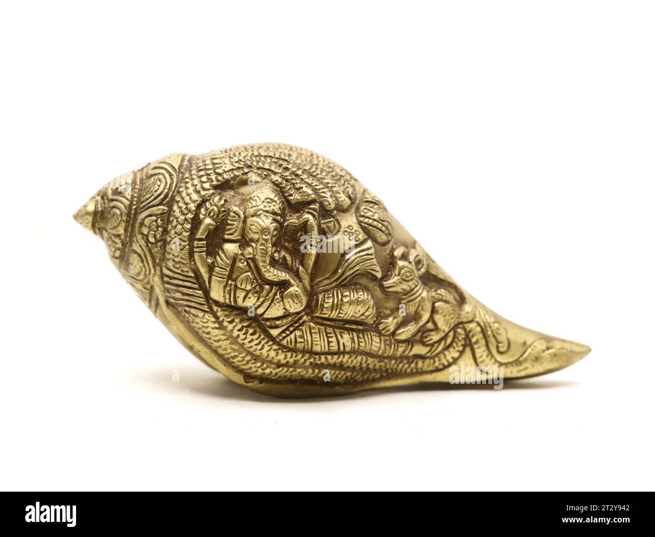 antique ganesha sculpture handcrafted with details on a religious conch shell made of brass used in temple and religious rituals isolated Stock Photo