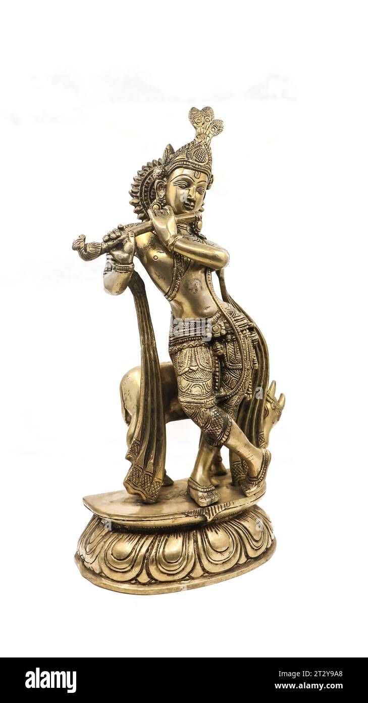 golden statue of lord krishna crafted with details, an avatar of vishnu, playing flute music near a cow in a dancing position, isolated Stock Photo