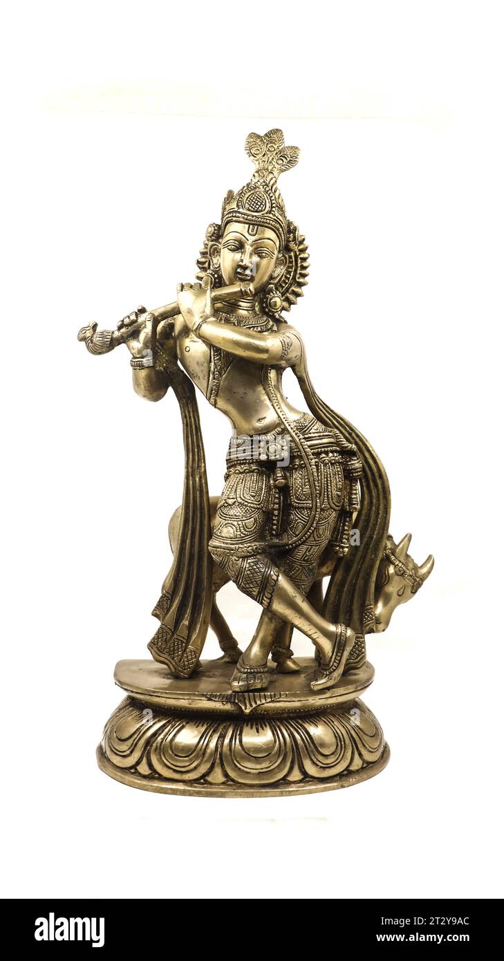golden statue of lord krishna crafted with details, an avatar of vishnu, playing flute music near a cow in a dancing position, front view isolated Stock Photo