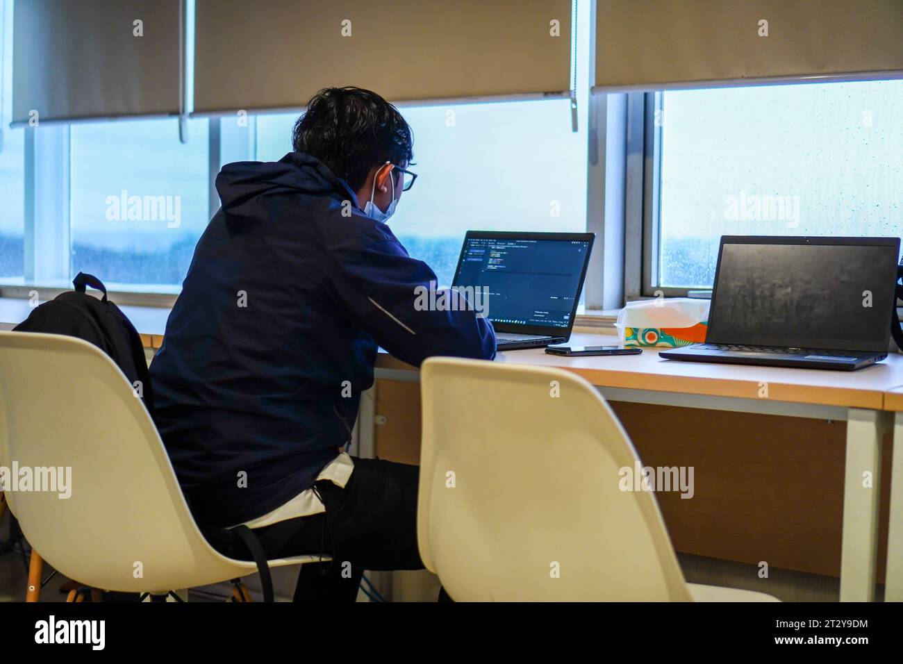 Software developer working on project in office, overlooking the window ...