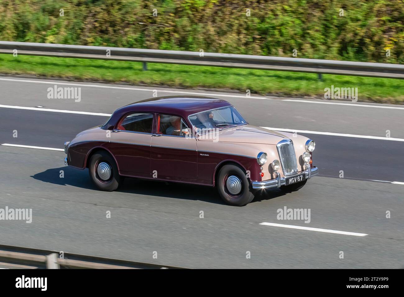 1958 50s fifties Riley 2.6 Maroon Petrol saloon 2639 cc. Riley-Two-Point-Six 4-Door 2.6L BMC C-Series Straight-6 Cylinder 101bhp Engine; travelling at speed on the M6 motorway in Greater Manchester, UK Stock Photo