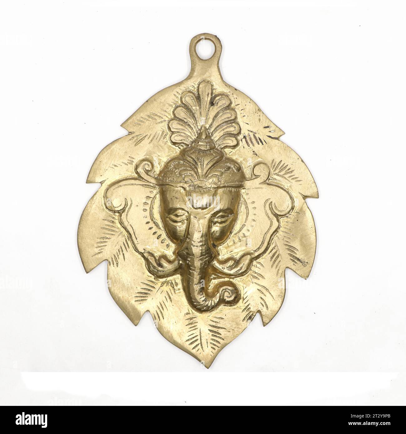 hindu god lord ganesha face antique sculpture on a leaf used as wall hanging display in gold isolated Stock Photo