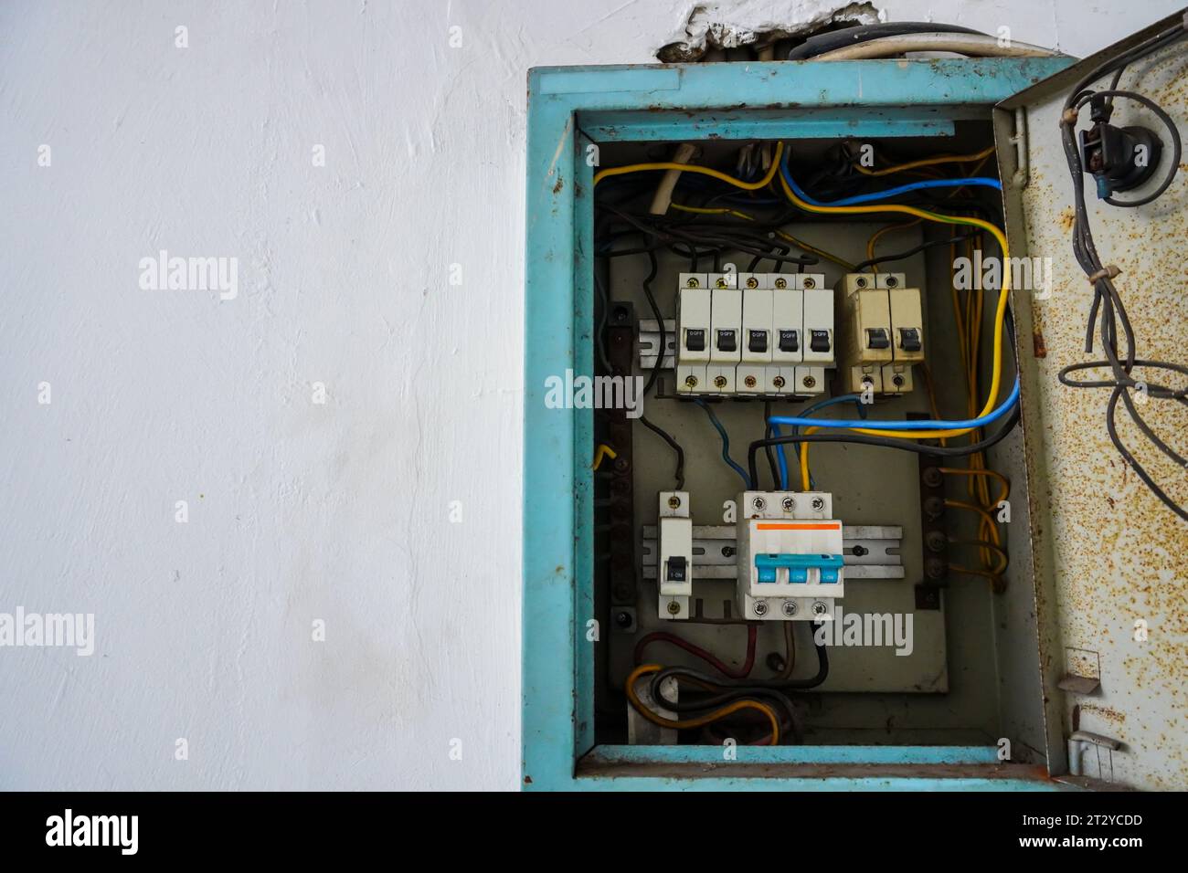 Circuit breaker panel. Electrical distribution for multiple rooms in a building, featuring a white wall background Stock Photo