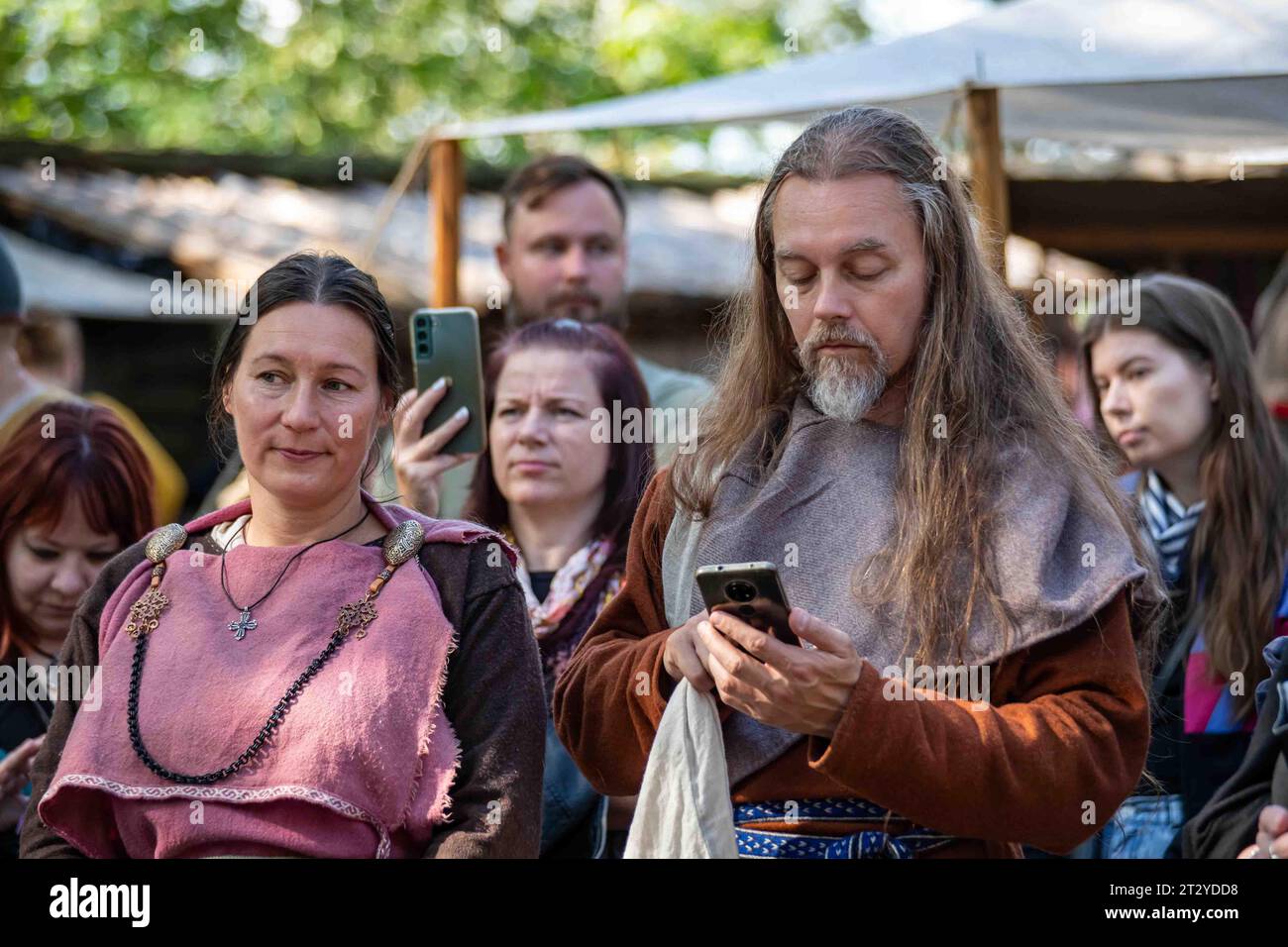 Pukkisaari Iron Age Market re-enactor with mobile phone in Helsinki, Finland Stock Photo