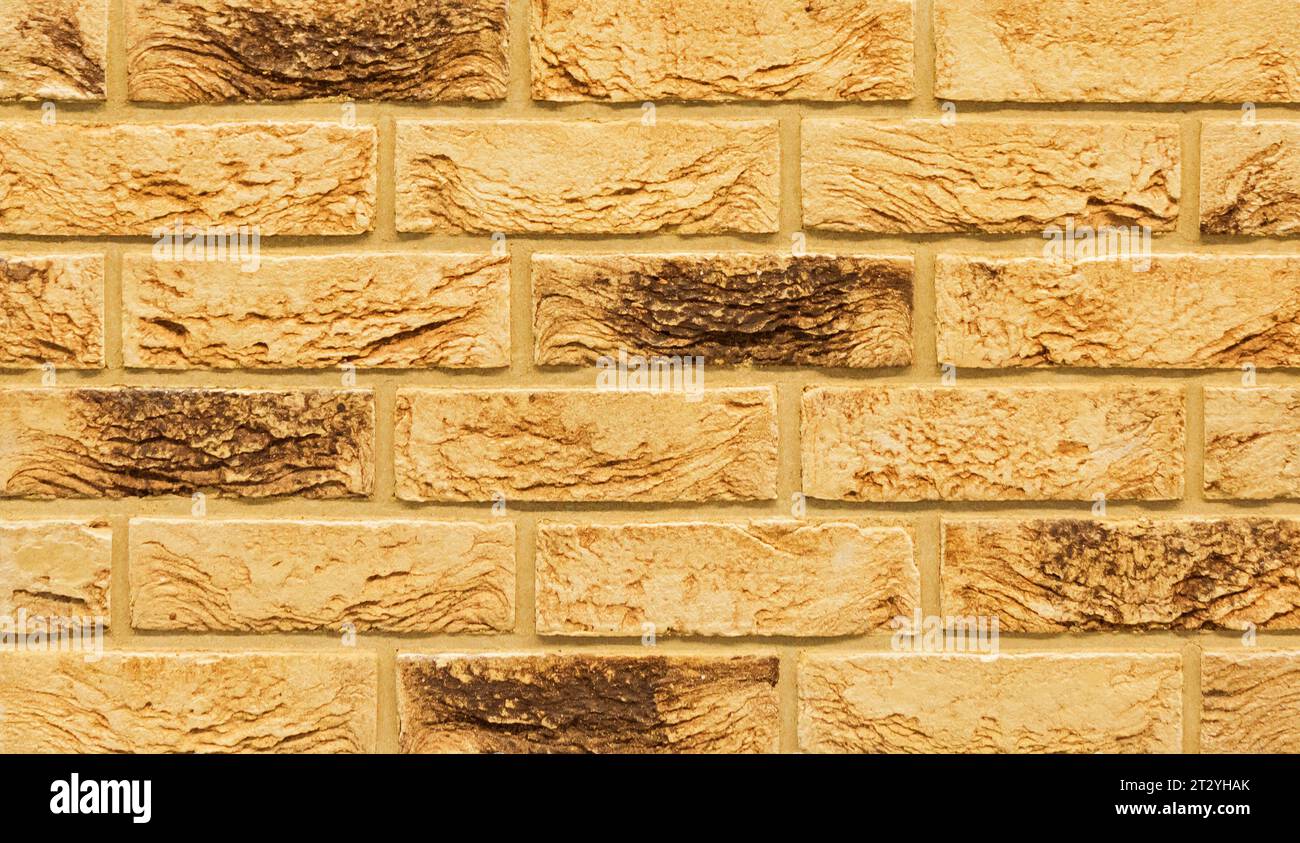 Old beige color stone material brick wall pattern background Stock Photo