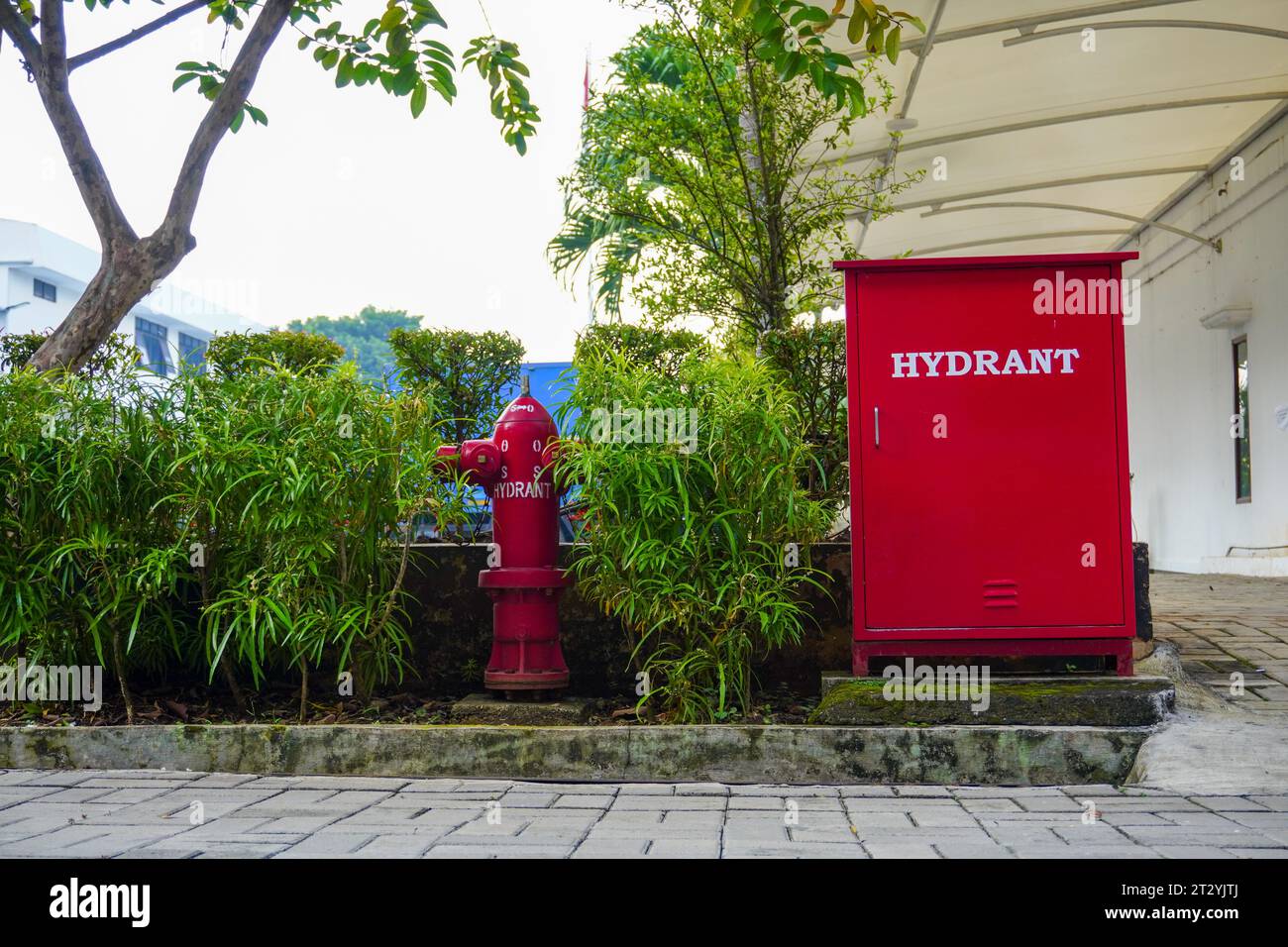 Outdoor fire safety equipment: red Hydrant box and emergency water pump, taken from a lower angle Stock Photo