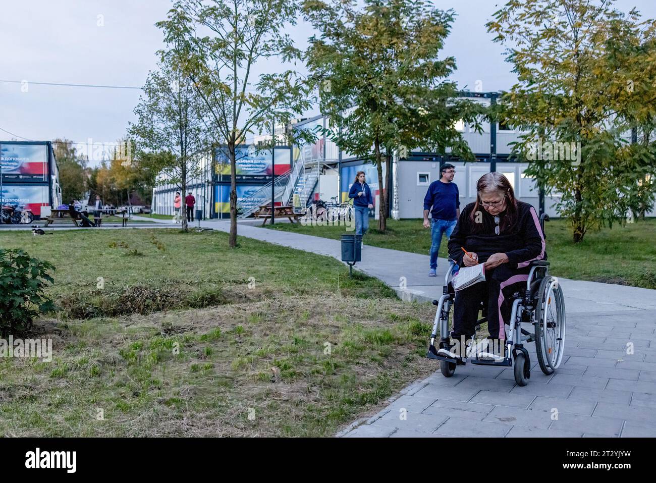 A disable refugee is seen on the road leading to the modular housing complex for internal displaced refugees in a residential area in Lviv. Modular housing settlement for refugee, facilitated by Warsaw University of Technology and the Polish government, are built in a residential area in Lviv as a prototype settlement including social infrastructure, based on replicable elements at micro, mezzo, and macro scales, to host approximately 3500 people displaced internally in Ukraine due to the Russian-Ukrainian War. (Photo by Hesther Ng/SOPA Images/Sipa USA) Stock Photo