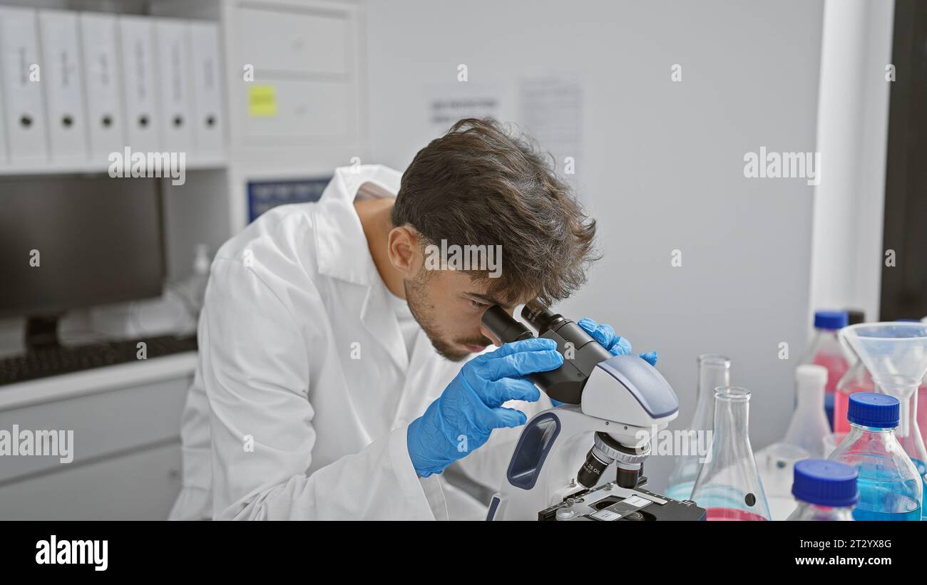 Young arab man scientist using microscope at laboratory Stock Photo