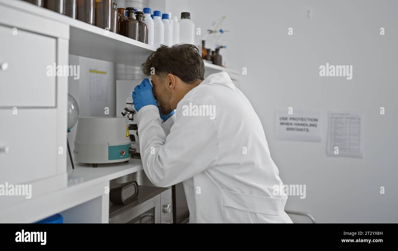 Young arab man scientist using microscope at laboratory Stock Photo
