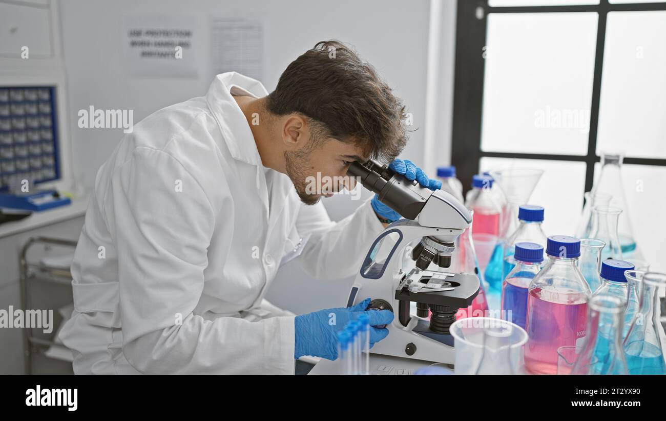 Young arab man scientist using microscope at laboratory Stock Photo