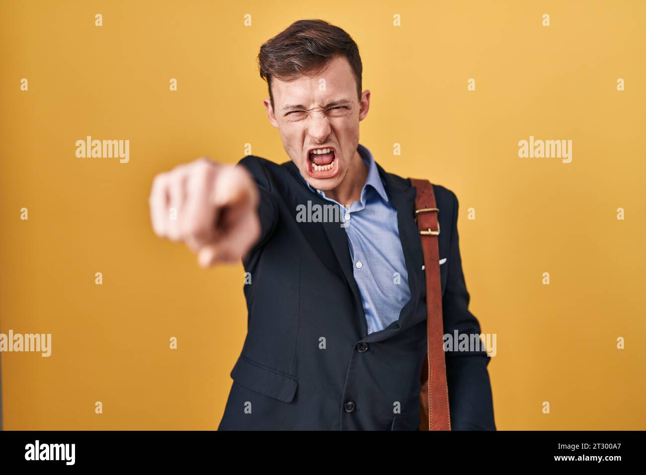 Caucasian business man over yellow background pointing displeased and ...