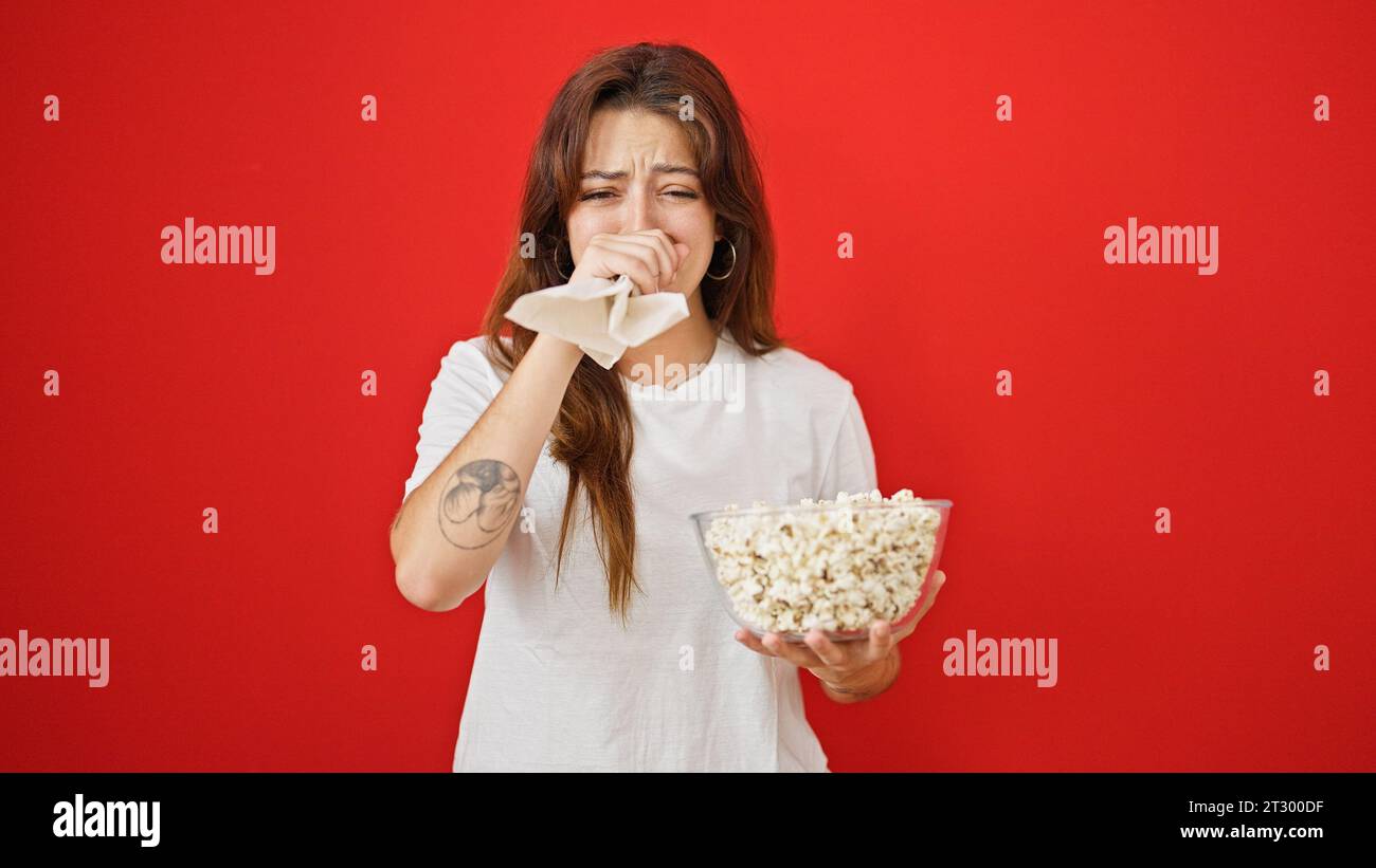 Young beautiful hispanic woman watching drama movie eating popcorn