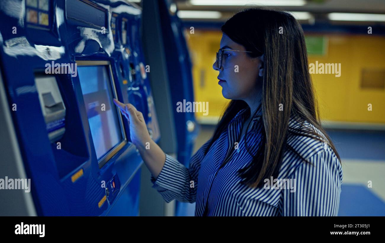 Young beautiful hispanic woman buying subway ticket at vending machine ...