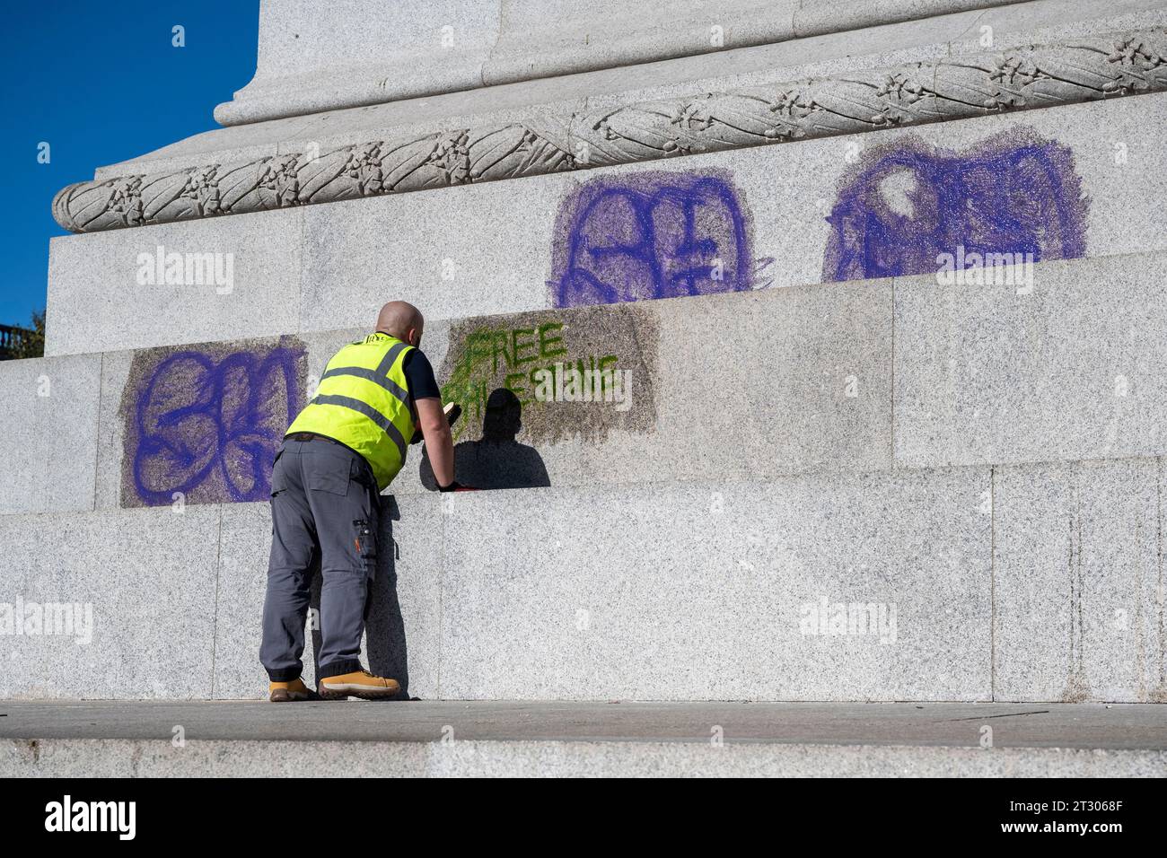 London UK 22 October 2023 A Workman Cleans Graffiti From The Base Of london-uk-22-october-2023-a-workman-cleans-graffiti-from-the-base-of