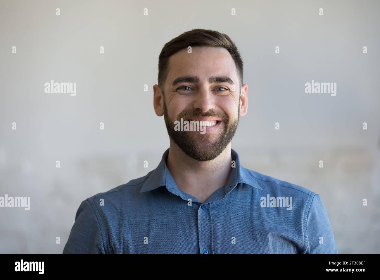 Happy man in casual blue shirt looking at camera Stock Photo