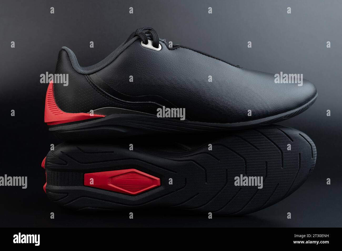 Black leather fitness shoes with red sole isolated on black studio background Stock Photo