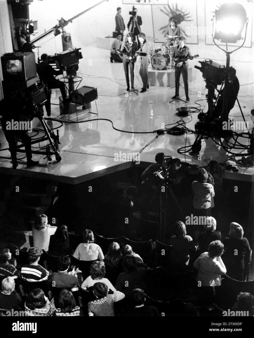 THE BEATLES PAUL McCARTNEY GEORGE HARRISON RINGO STARR and JOHN LENNON on set candid during filming at the Scala Theatre of concert finale scene and audience for A HARD DAY'S NIGHT 1964 director RICHARD LESTER Walter Shenson Films / Proscenium Films / United Artists Stock Photo