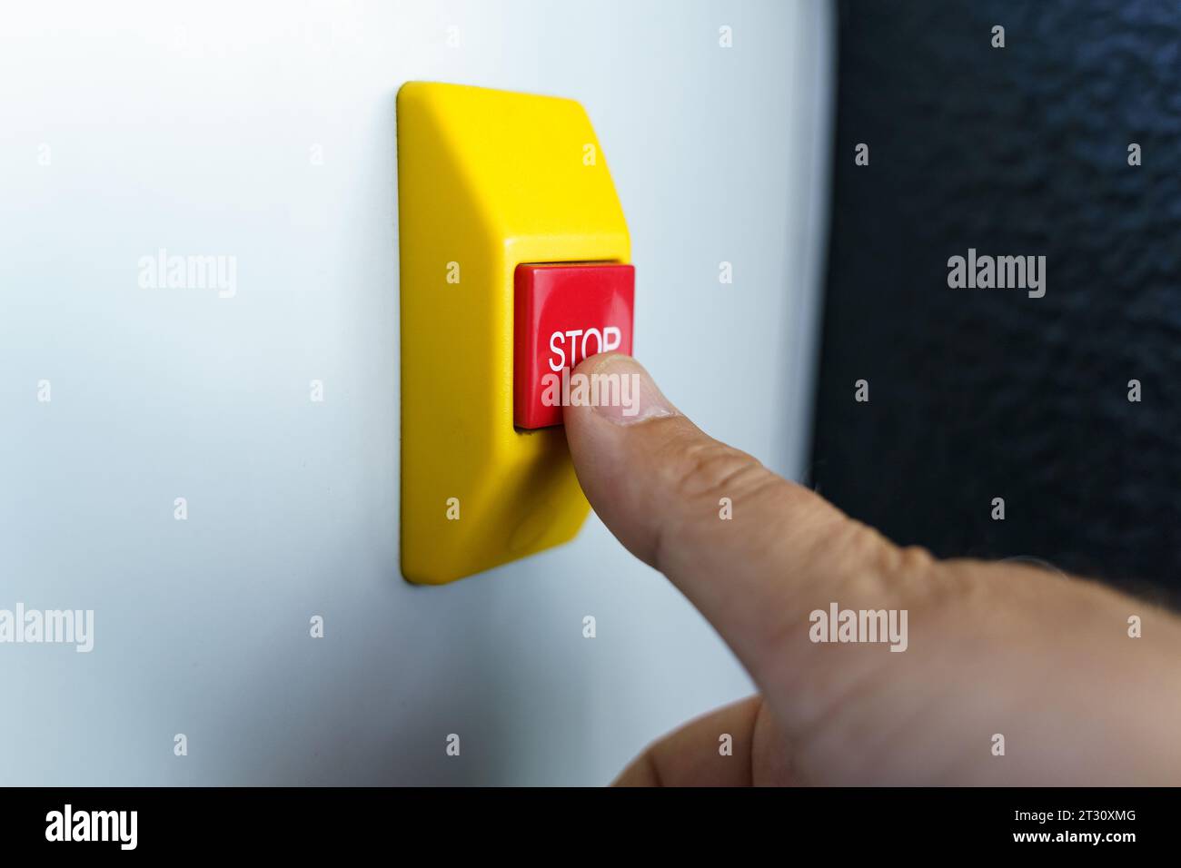 Stop Hand Button Stop button and the hand of a worker about to press it. Emergency stop ...