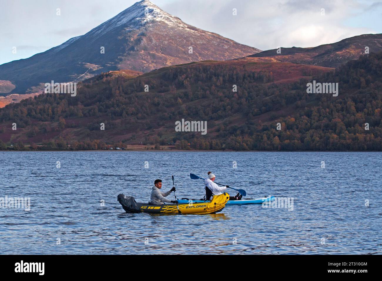 Loch Rannoch, Perth and Kinross, Scotland, UK 22nd October 2023. Nathan and Abigail, husband and wife from Glasgow set out for watersport exercise on Loch Rannoch with snow capped Schiehallion mountain in background. Stock Photo
