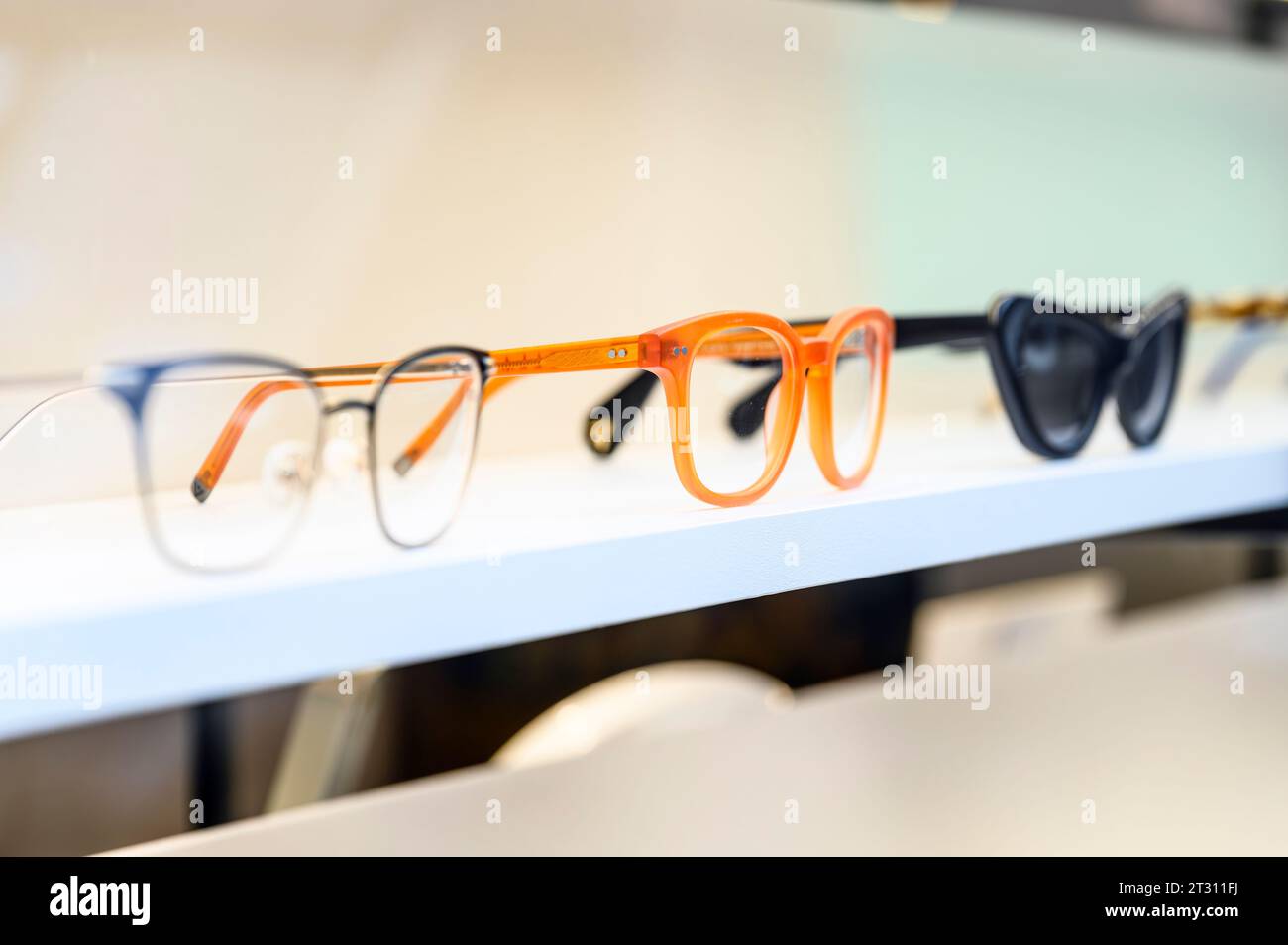 Orange colour glasses on display in an opticians window Stock Photo