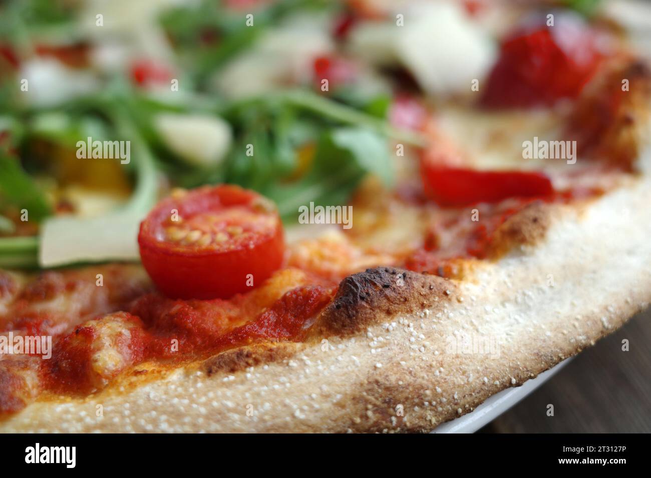 Delicious vegetarian pizza with tomatoes, arugula leaves and parmesan cheeseDelicious vegetarian pizza with tomatoes, arugula leaves and parmesan chee Stock Photo
