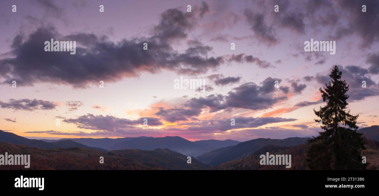 dramatic cloudscape above the mountains at dusk. sky in colorful evening light. changing weather forecast Stock Photo